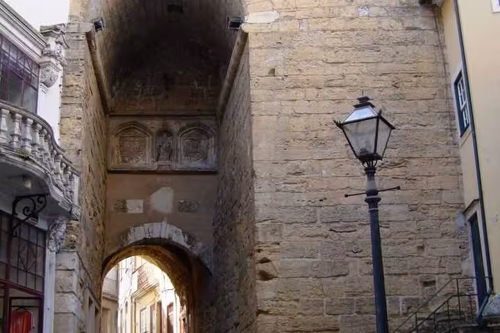 Historic stone archway in Coimbra's charming old town, showcasing medieval architecture.