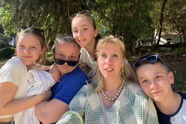 Family taking a selfie in Coimbra park during a self-guided scavenger hunt walking tour with sightseeing clues