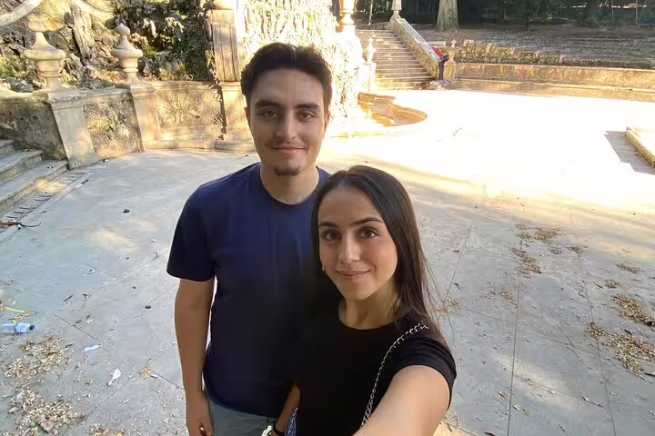 Couple at Coimbra landmark plaza during a self-guided scavenger hunt and sights tour, exploring historic sites