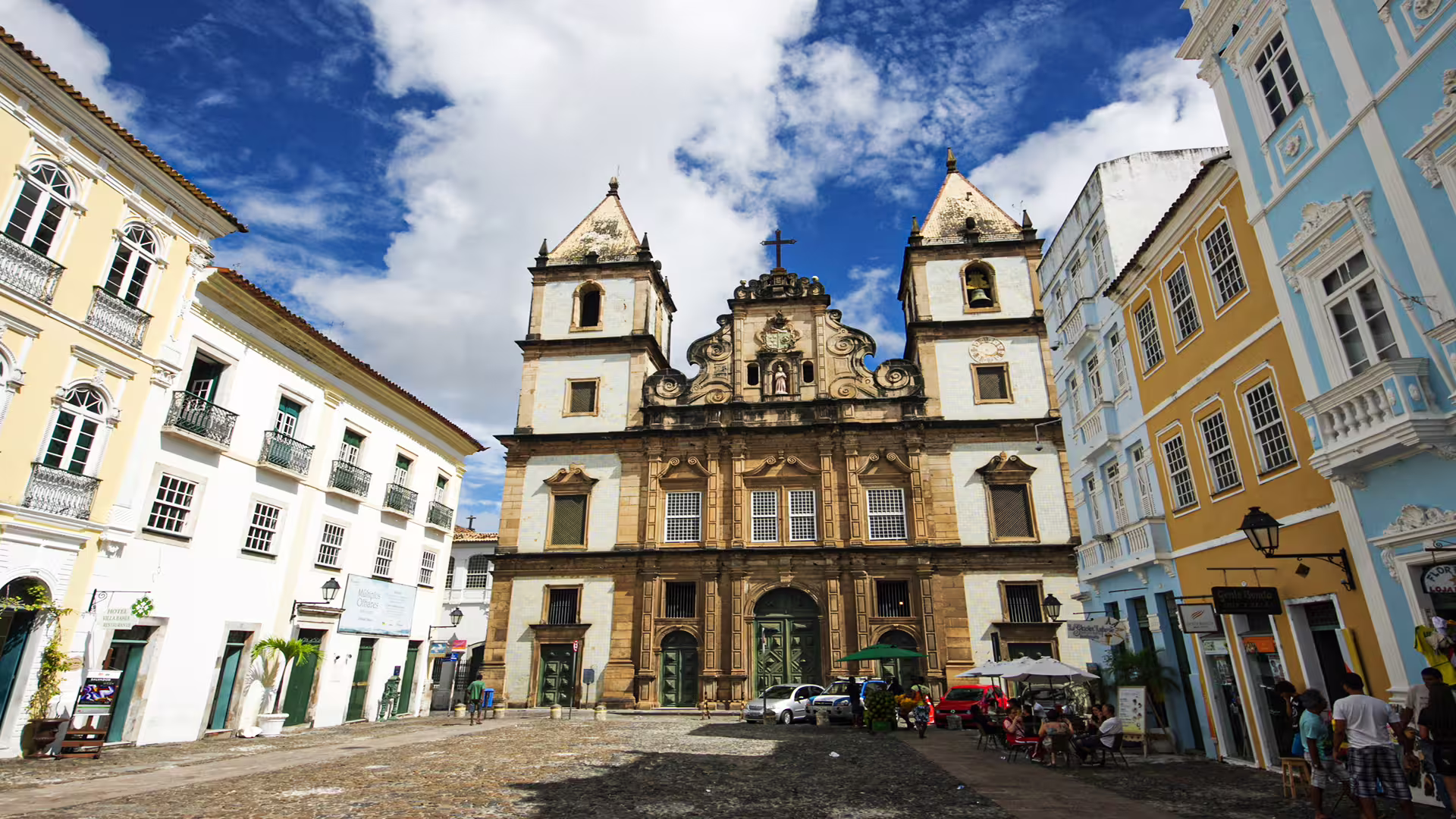 Historic square with colorful colonial buildings and a baroque church, ideal for a private tour to University of Coimbra.