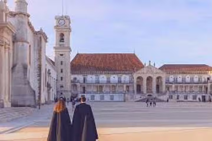Visitors exploring the historic University of Coimbra courtyard during a private full day tour from Lisbon to Tomar and Coimbra.