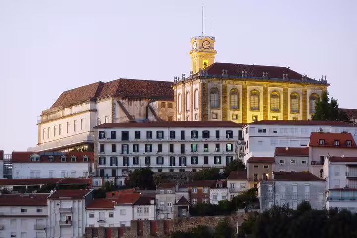 Scenic view of Coimbra University illuminated at dusk, highlighting its historical architecture on the Porto to Fátima tour.