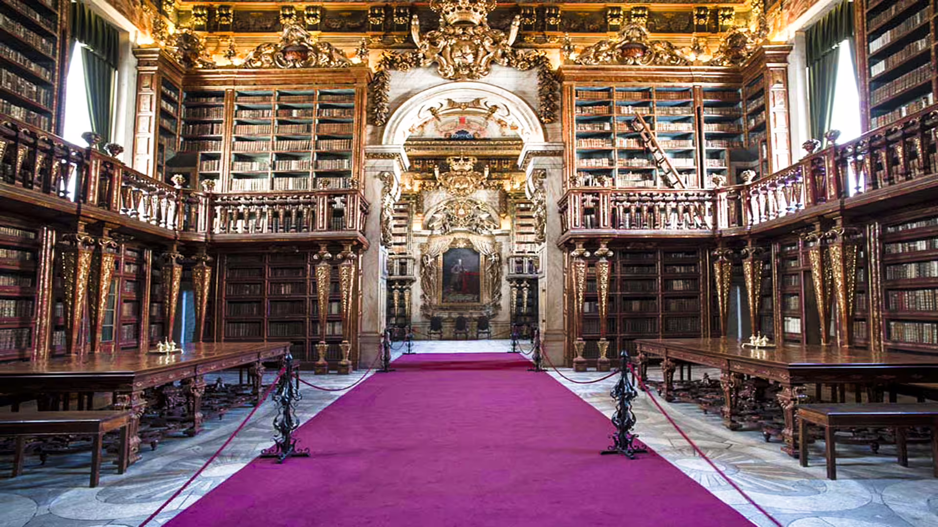 Ornate interior of the University of Coimbra library with grand bookshelves and opulent decor, featured in private tour.