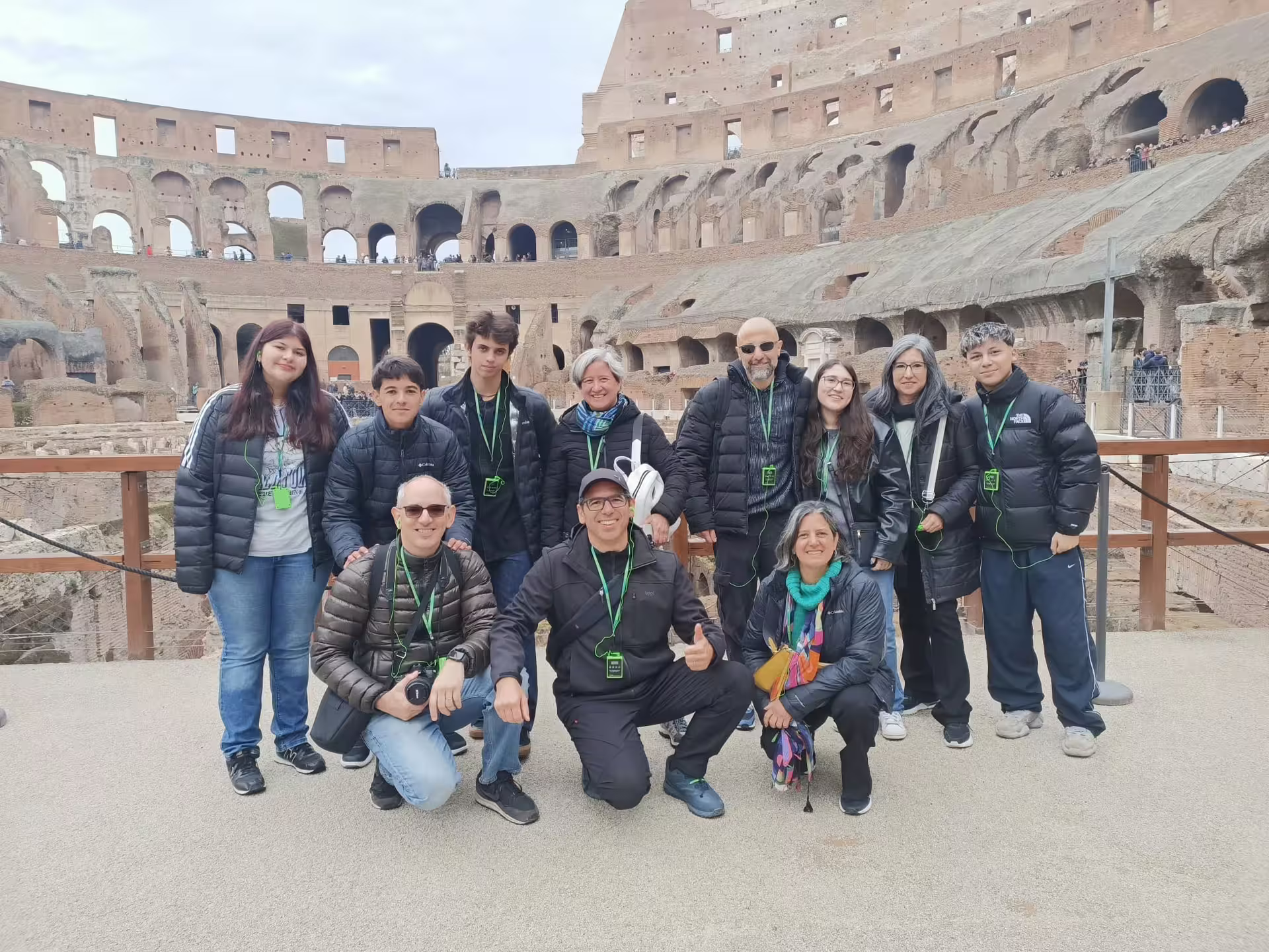 Grupo de viajeros dentro del Coliseo en tour guiado con auriculares, visita Arena, Foro Romano y Monte Palatino