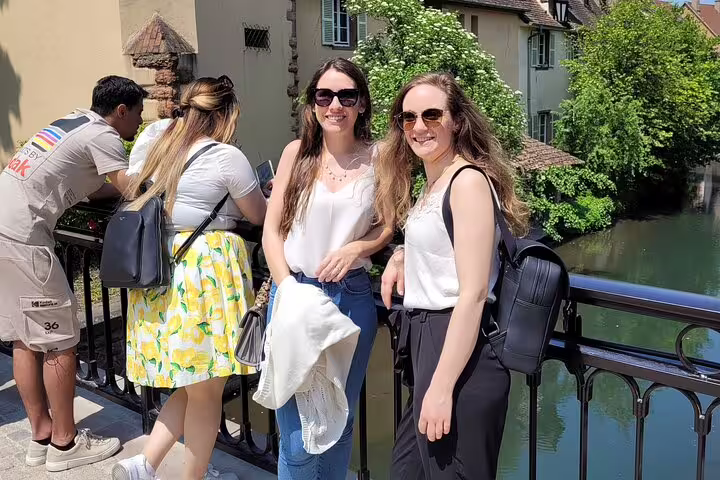 Friends on a canal bridge in Colmar during a self-guided scavenger hunt walking tour in Little Venice