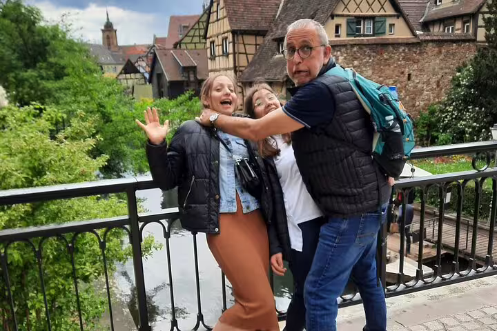 Friends posing on a bridge over Colmar’s Little Venice, fun clue stop on a self-guided scavenger hunt