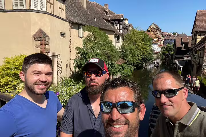 Friends on a bridge over La Petite Venise canal, exploring Colmar sights on a self-guided scavenger hunt tour