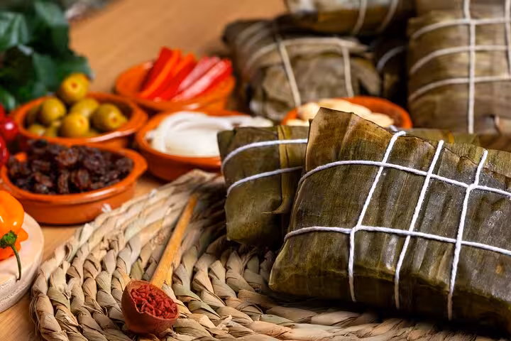 Traditional Colombian tamales wrapped in banana leaves, accompanied by fresh ingredients in Medellín's Laureles food tour.