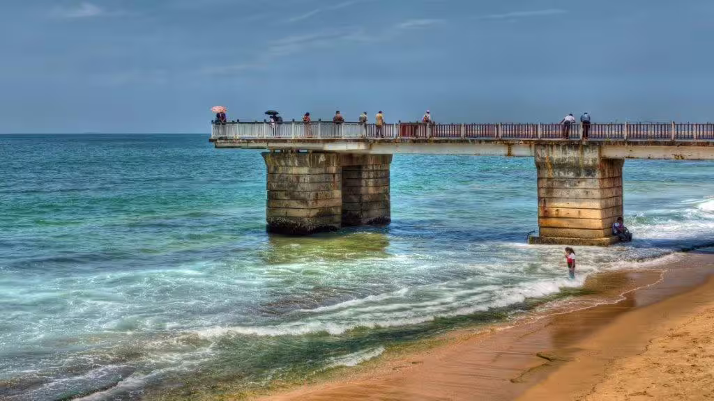 Scenic view of Colombo beach with a pier extending over turquoise waters, perfect for a relaxing city escape.