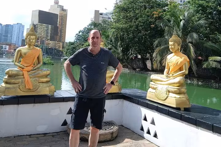Traveler at Beira Lake with golden Buddha statues, Colombo tuk tuk city tour all-inclusive low price