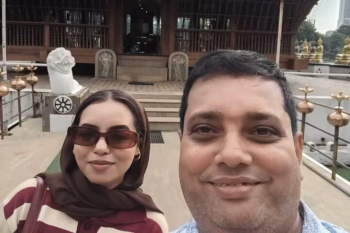 Traveler and tuk tuk driver selfie at Gangaramaya Temple in Colombo, cultural stop on city tuk tuk tour