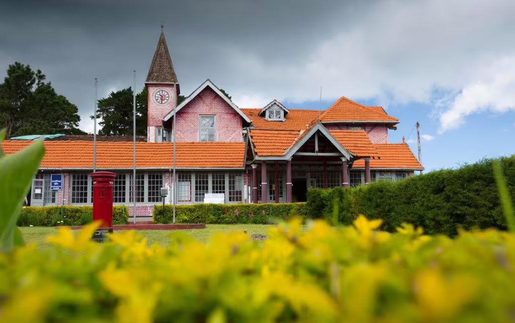 Charming colonial-era building with red-tiled roof set against a cloudy sky in Nuwara Eliya, Sri Lanka.