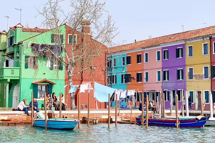 Colorful Burano waterfront houses and moored boats, stop on private Murano & Burano boat tour