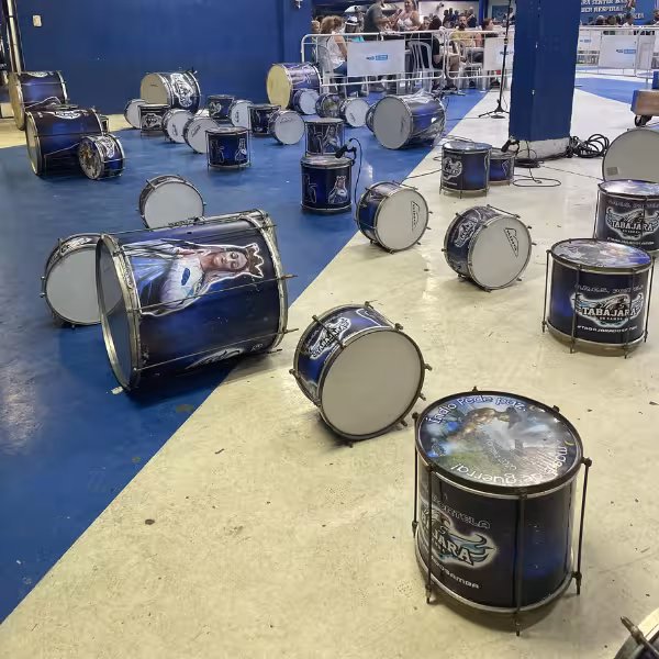 A collection of colorful drums on the floor ready for the energetic samba school rehearsal experience.