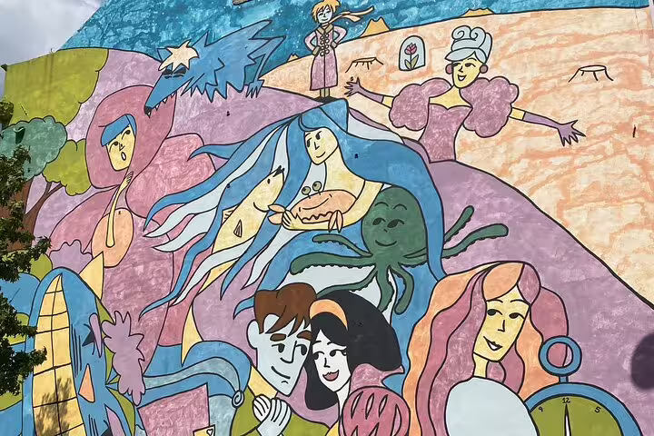 Colorful mural depicting whimsical characters and scenes in Lisbon, showcasing vibrant urban art on a wall.