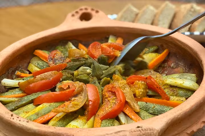 Close-up of a colorful vegetable tagine being prepared with fresh ingredients during a cooking class experience.