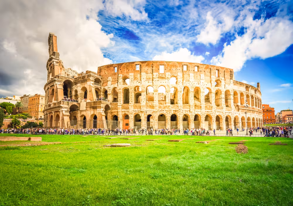 Vibrant view of the Colosseum in Rome under a partly cloudy sky, perfect for a semi-private tour of ancient landmarks.