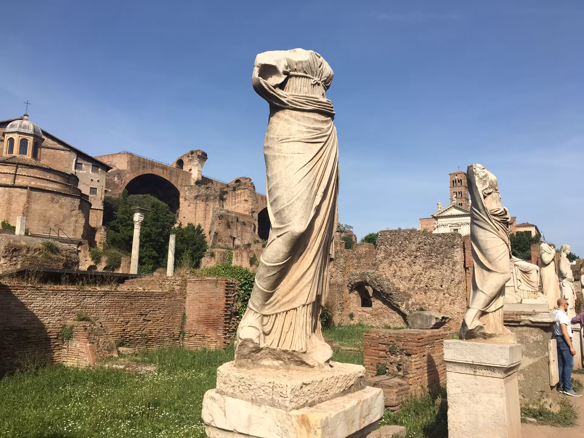 Ancient marble statues in Roman Forum with Colosseum Arena Combo Tour, showcasing Rome's rich history and ruins.