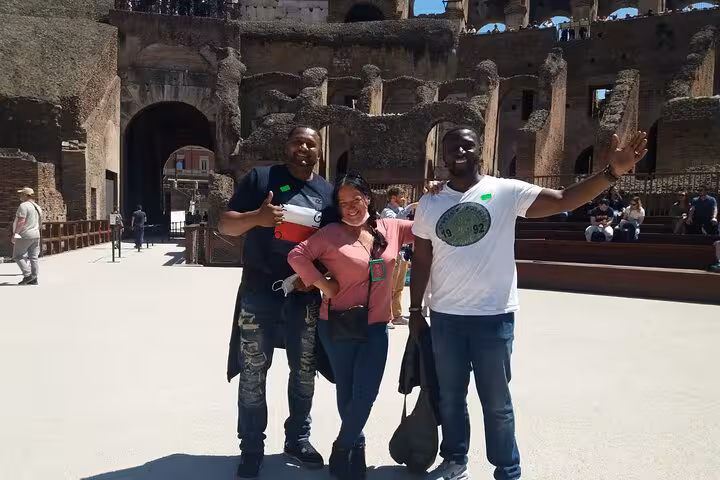 A group poses on the iconic arena floor inside the Colosseum, highlighting the immersive Roman Forum experience.
