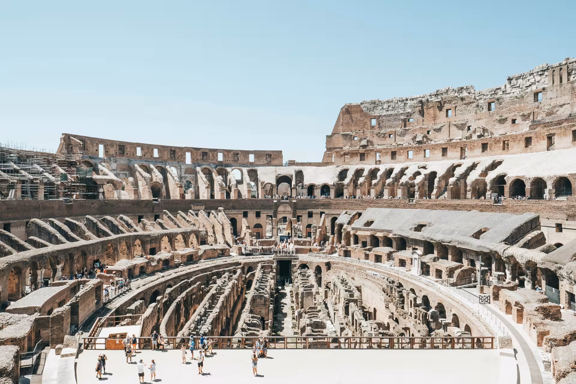 Stunning interior view of the Colosseum, highlighting ancient architecture and tour groups exploring the historic arena.
