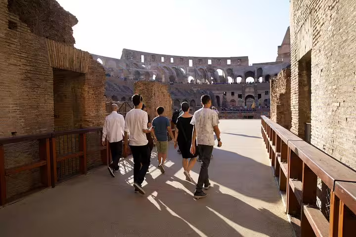 Small group walking onto the exclusive Colosseum gladiator arena floor during a guided tour of Rome’s ancient amphitheatre
