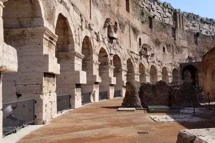 Stone arches and walkways of the Colosseum interior captured on a small-group gladiators arena floor guided tour in Rome