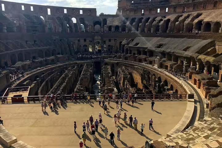 Tour group exploring the Colosseum arena floor with views of the hypogeum on an exclusive gladiators guided tour in Rome