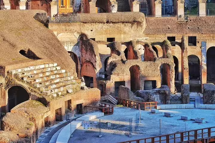 Sunlit ruins of the Colosseum arena floor and ancient seating area explored on a VIP gladiators underground tour in Rome