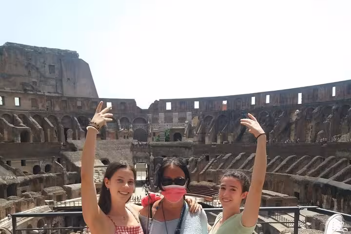 Visitors enjoying a guided tour inside the historic Colosseum, showcasing its magnificent ancient architecture.