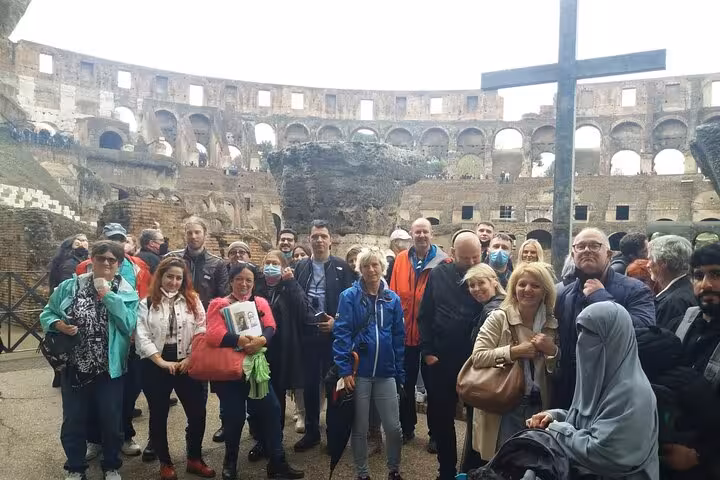 A diverse tour group explores the Colosseum's interior, highlighting its rich history and architectural grandeur.
