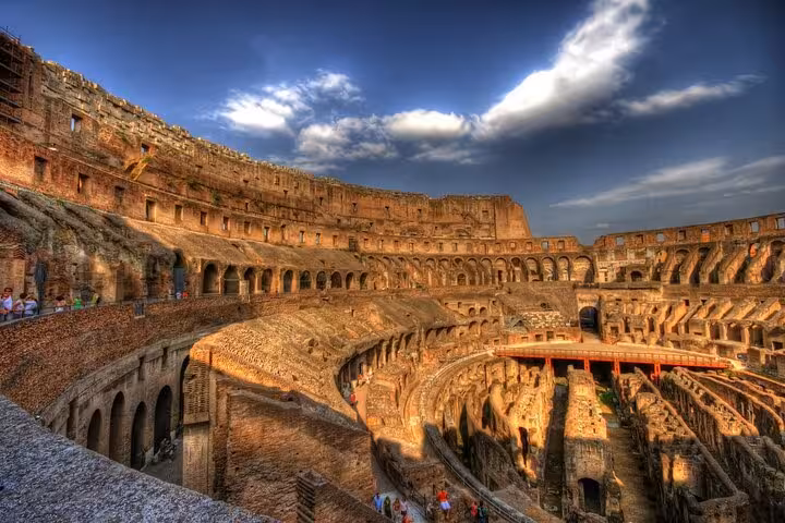 Stunning view of the Colosseum's interior under dramatic skies, highlighting the ancient arena's architectural grandeur.