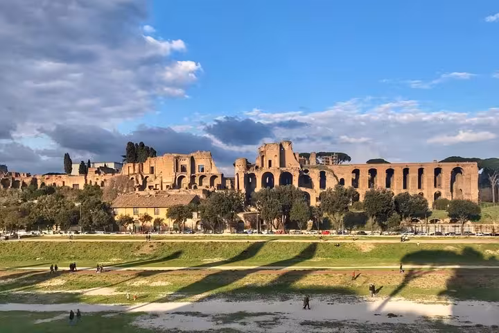 Discover the majestic ruins of the Roman Palatine Hill under a vibrant sky during the Colosseum tour.