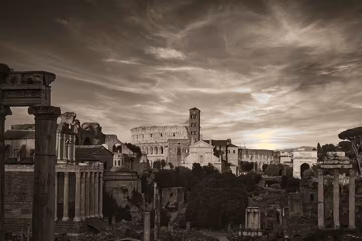 Dramatic view of Colosseum and Roman Forum ruins under a cloudy sky, perfect for history tours.