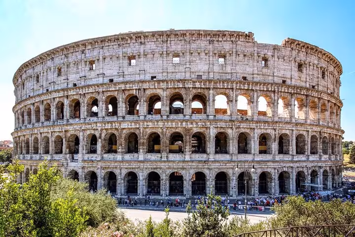Daytime view of the Colosseum in Rome, showcasing its iconic arches, included in the Colosseum and Vatican guided tour.
