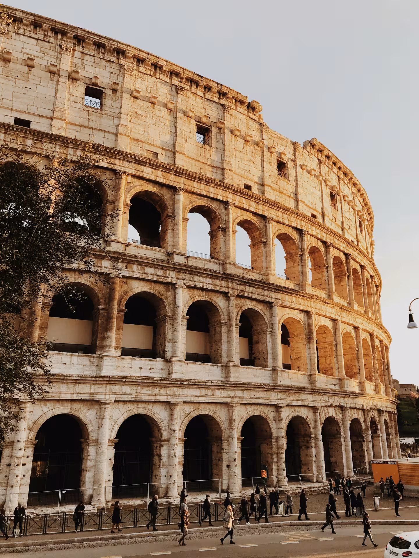 View of the Colosseum in Rome at dusk, showcasing its iconic arches and historic architecture for a cultural tour.