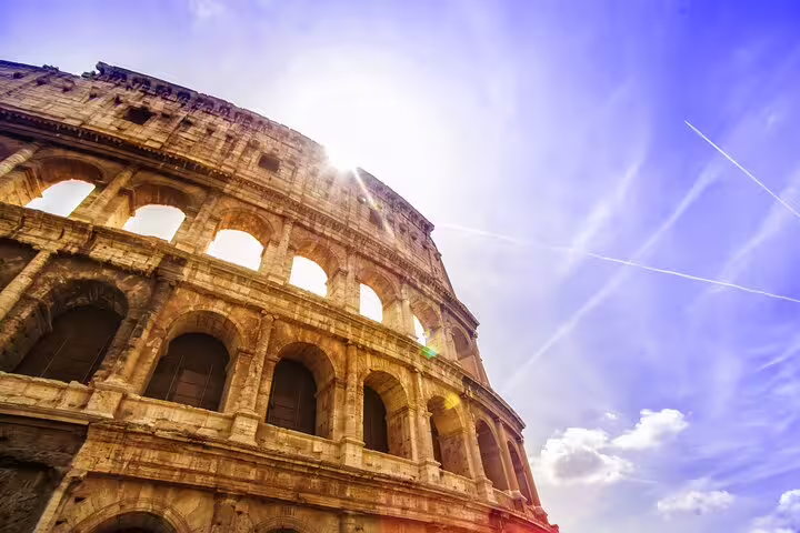 Sunlit Roman Colosseum exterior with blue sky, ideal for private arena floor tour with expert local guide in Rome