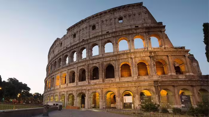 Sunset view of the illuminated Colosseum in Rome, featured on the 9 days self drive In the Heart of the Divine Country Tour