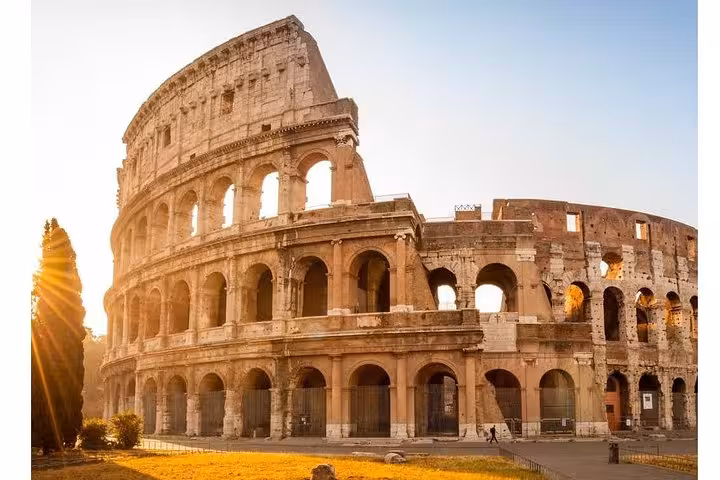Majestic sunrise over the Colosseum, illuminating its ancient arches and historical grandeur in the heart of Rome.