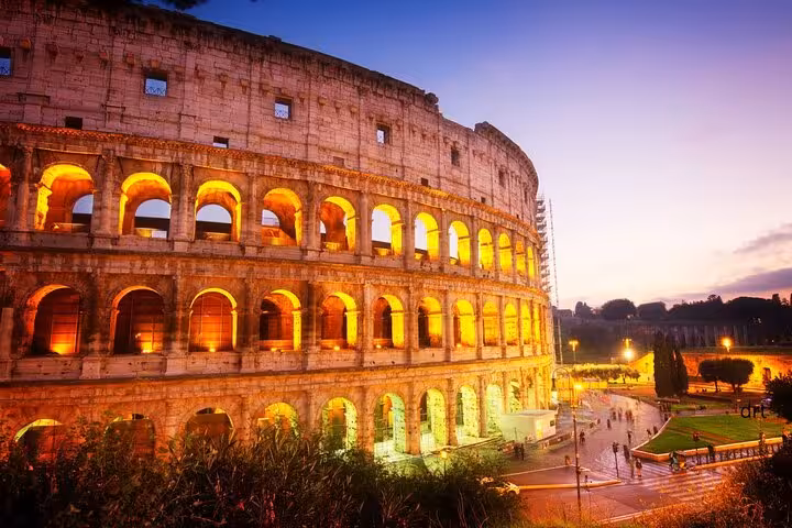 The Colosseum illuminated at sunset, offering a stunning view for visitors on the Colosseum and Vatican guided tour.