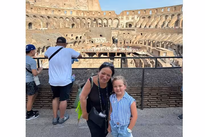Visitors enjoying a family moment inside the historic Colosseum during a shared tour experience in Rome.