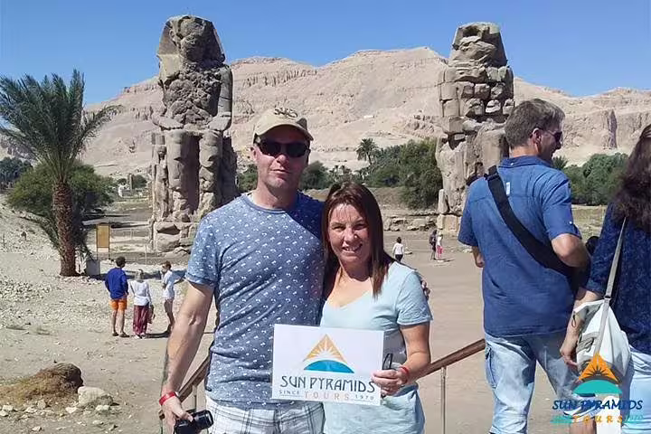 Couple at Colossi of Memnon, West Bank Luxor, on 5 days Cairo to Luxor Egypt package tour with guide