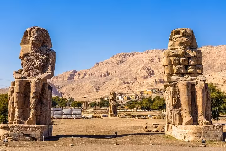 Colossi of Memnon statues on Luxor West Bank with desert hills, iconic stop on guided day tour