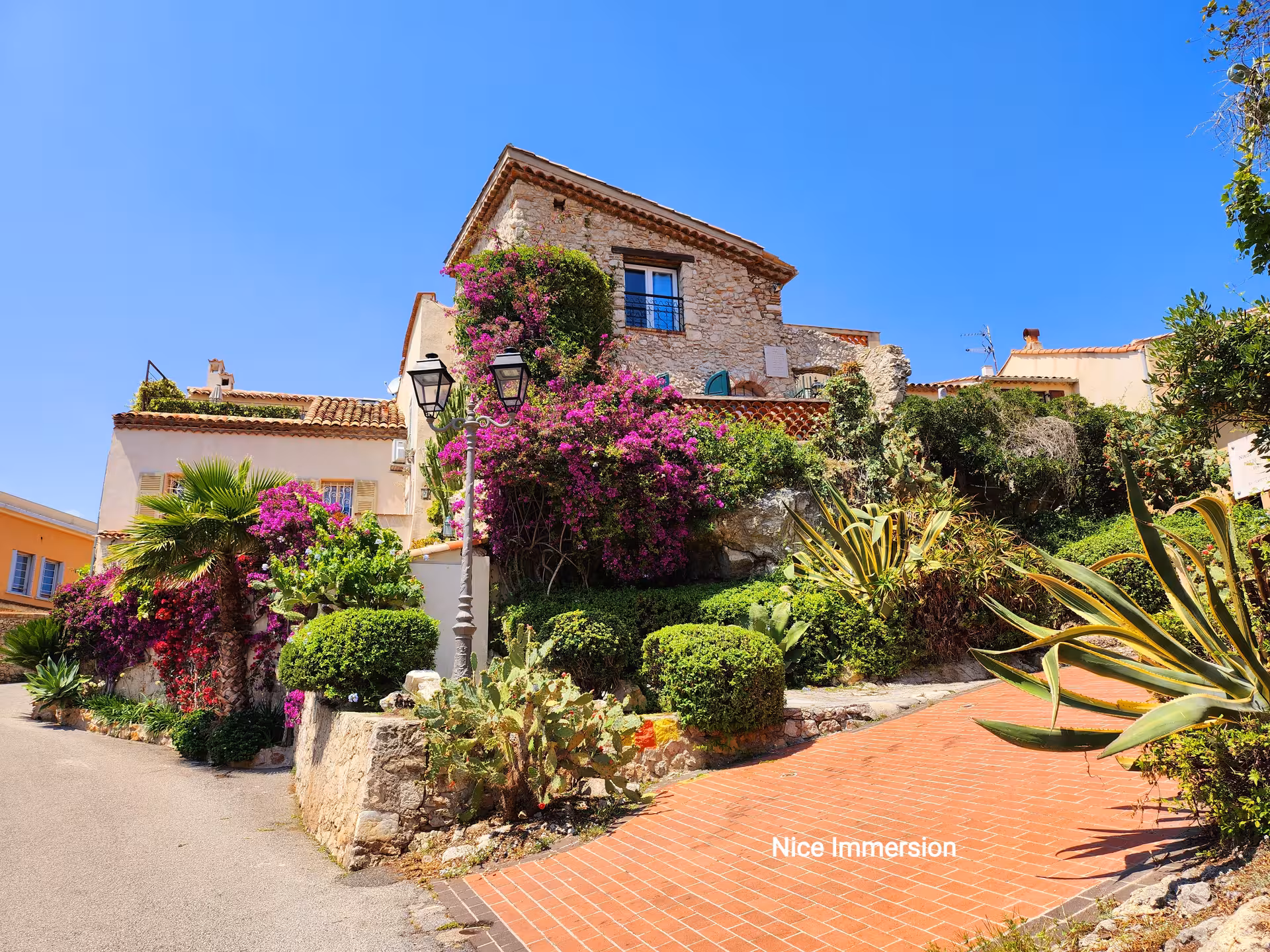 Charming Mediterranean house adorned with lush greenery and vibrant flowers, perfect for Colourful Excursion tours.