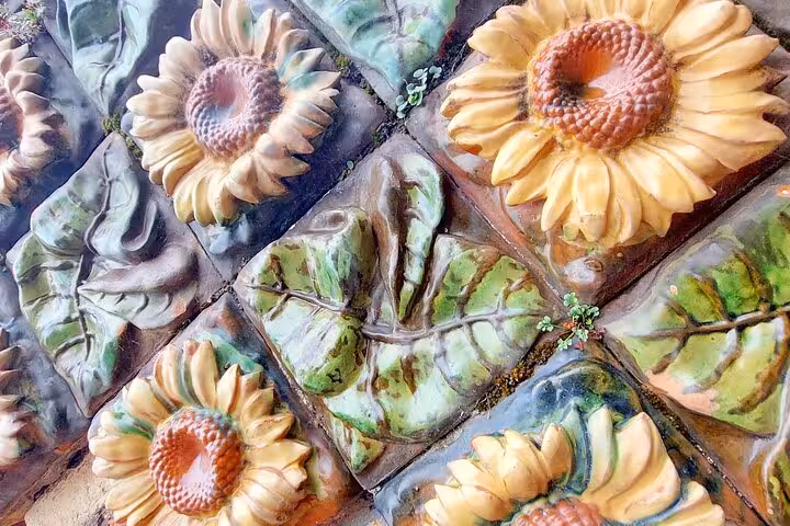 Vibrant sunflower and leaf tiles in Comillas, illustrating unique Gaudi-inspired modernist art.