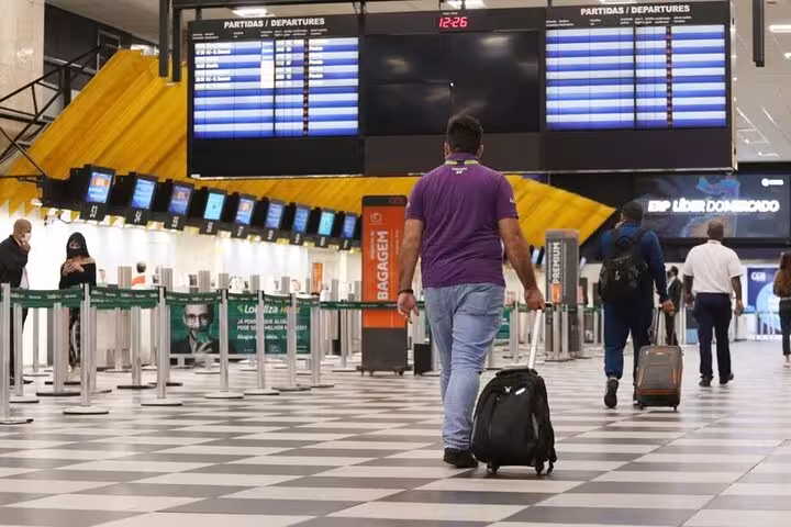 Travelers at Congonhas Airport navigating departures for São Paulo hotel transfer service.