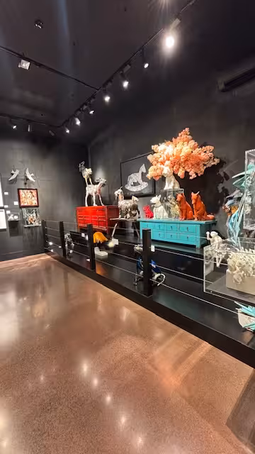 Contemporary art gallery with vibrant animal sculptures and creative installations on display for sculpture tour.