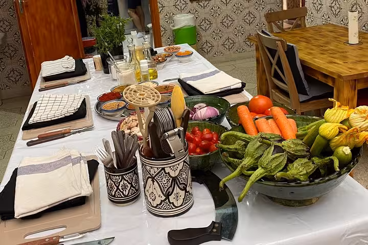 Table set for cooking class with fresh vegetables, spices, and traditional utensils at Yassine & Mom's kitchen.