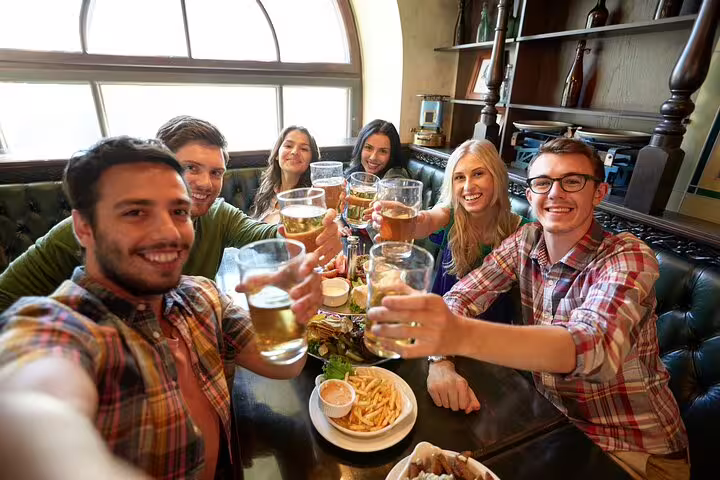 Group of friends enjoying beers and Scandinavian cuisine at a cozy Copenhagen pub during a private food and drink tour.