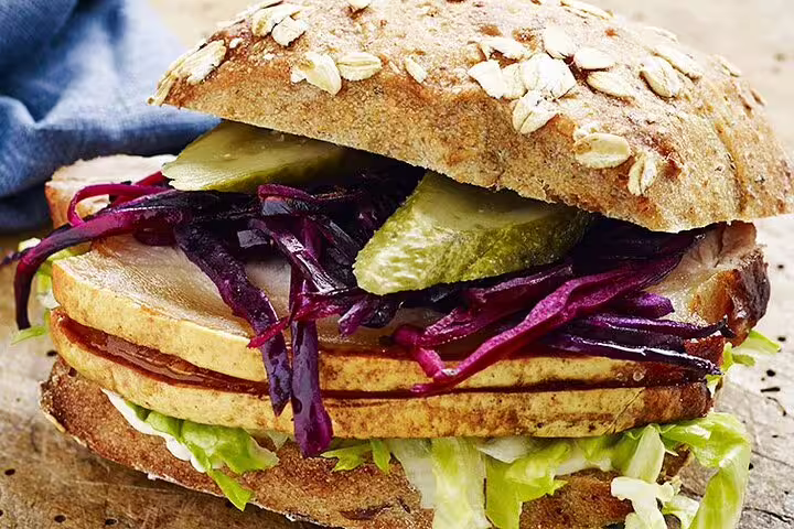 Artisanal rye sandwich with pickled veggies and fresh lettuce, featured on Copenhagen's Scandinavian Delights Tasting Tour.