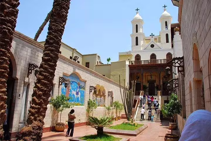 Coptic Cairo church courtyard with palm trees and visitors, part of Egyptian Museum, Citadel and Nile dinner cruise tour